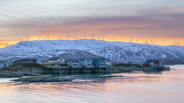 北大西洋岸の美しいカラフルな家と丘の上の風力タービンで素晴らしい日の出を背景に ヒルジー島とソマリー島の木造別荘 湖のそばの赤い家 トロムズ ノルウェー北部 — ストック写真