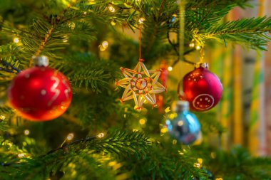 Noel ağacındaki süs eşyalarının arasında saman yıldızı. Arkaplan resmi: Işıklar karanlıkta parlıyor, bu Noel süsü..