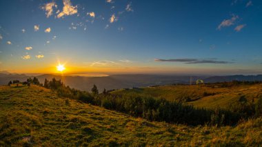 Gün batımında paraşütle paraşütle atlayan alp manzarası yeşil çayır, köknar ağacı, turuncu aynalı su ve dağ sırası ile Constance Gölü. Bregenz Ormanı, Vorarlberg, Avusturya 'da bir yaz gününde mavi bulutlu gökyüzü