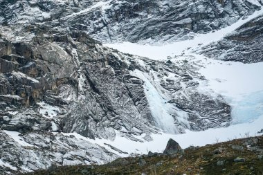 Norveç 'te kışın ilginç yapılandırılmış kayalarla dolu engebeli dağ zirveleri, karla kaplı kaya yüzeyleri arasında uçurumlar, Kvalya' daki uçurumlarda karlı dik yamaçlar, buzlu tarlalar ve buzullarla