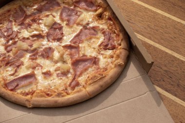 05.04.2023 Viyana, Avusturya. Paket Asistanı Hawaii pizzası. Domates soslu, peynirli, jambonlu, ananaslı.