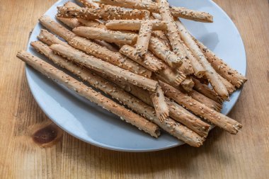 Avusturya, Viyana - 22 Mayıs 2023 Lezzetli klasik çıtır ekmek çubukları (Grissini) beyaz bir tabakta