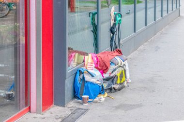 Viyana, Avusturya. 4 Nisan 2023. Evsiz bavulları bir süpermarkete bağlı.