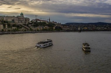 Budapeşte, Macaristan - 16 Nisan 2023 Hungary 'nin nehir kıyısındaki hazineleri Tuna nehri, gemiler ve muhteşem turistik yerleri kapsıyor..