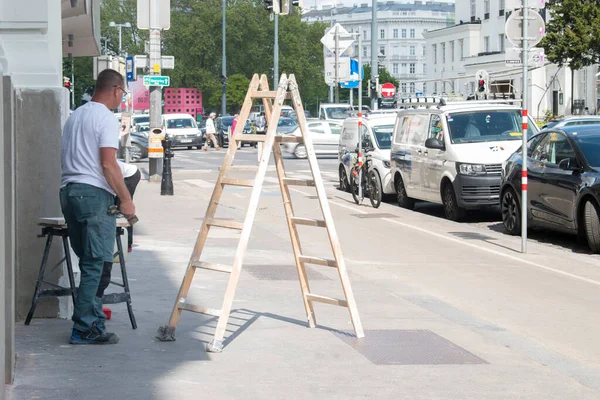 stock image vienna, austria. 10 may 2023 transforming roads, unyielding determination a man and a ladder working tirelessly