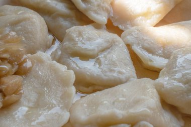Otantik cilacı pierogi, bu geleneksel yemeğin lezzetli ve rahatlatıcı özelliklerini sergileyerek, bir tabakta karamelize edilmiş soğan eşliğinde mükemmelliğe ulaşır..