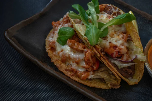 Flavorful Mexican-style tacos featuring succulent shrimp, tomatoes, cheese, chili, and onions, served with a side of hot and tangy Mexican sauce for a spicy and satisfying bite.
