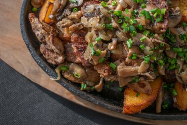 Yumuşak tavuk ciğeri ve dökme demir tavada pişirilmiş gevrek patates aromalı sarımsak, otlar ve kızarmış soğan. Kırsal bir dokunuşla lezzetli ve rahatlatıcı bir yemek.