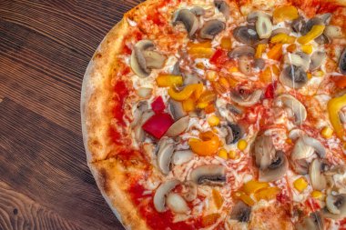 Funghi pizza: Domates soslu, erimiş peynirli, aromalı mantarlı, canlı biberli ve tatlı mısırlı ağız sulandıran bir pizza, hepsi de ahşap bir masada servis ediliyor. Tatmin edici ve sağlıklı bir yemek deneyimi için mükemmel bir lezzet kombinasyonu..