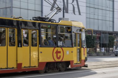 Varşova, Polonya. 16 Haziran 2023: Varşova 'nın canlı sarı tramvaylarıyla verimli şehir ulaşımı deneyimi, şehrin trafiğini sorunsuzca takip etmek ve Polonya başkentinin hareketli caddelerini keşfetmek için uygun bir yol sunmak.