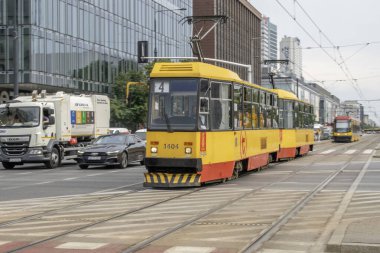 Varşova, Polonya. 16 Haziran 2023: Varşova 'nın canlı sarı tramvaylarıyla verimli şehir ulaşımı deneyimi, şehrin trafiğini sorunsuzca takip etmek ve Polonya başkentinin hareketli caddelerini keşfetmek için uygun bir yol sunmak.