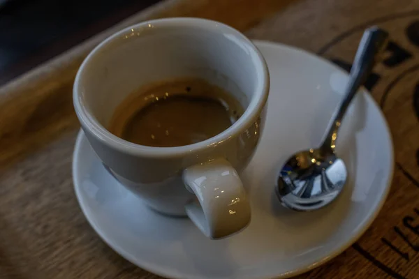 ブラックウッドテーブルの上に白いカップでホットエスプレッソコーヒーにショットアップ トップビュー — ストック写真