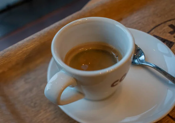ブラックウッドテーブルの上に白いカップでホットエスプレッソコーヒーにショットアップ トップビュー — ストック写真
