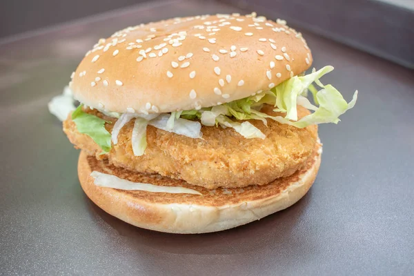 Burger Kurczaka Zwieńczony Świeżej Sałaty Serwowane Oszałamiającym Czarnym Tle Naturalnego — Zdjęcie stockowe