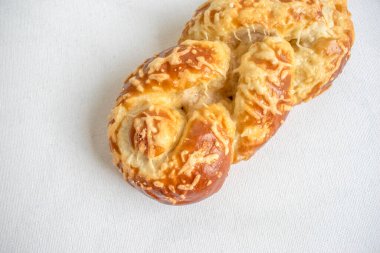 Soft pretzel bread topped with melted cheese, perfect for a savory and satisfying snack. Captured on a white background for a delicious presentation.