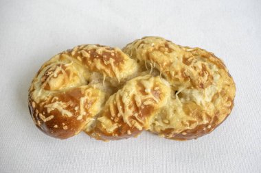 Soft pretzel bread topped with melted cheese, perfect for a savory and satisfying snack. Captured on a white background for a delicious presentation.