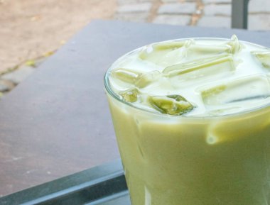 Klasik bir latte 'de yenileyici ve benzersiz bir karışım. Matcha ve chai' nin lezzetlerini birleştiriyor. Seçici odak, doğal bir arka plana karşı cazibeye katkı sağlar..