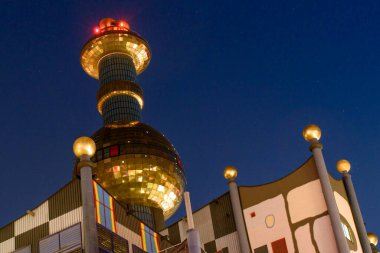 Viyana, Avusturya 20 Ağustos 2023: Spittelau - Viyana 'nın Hundertwasser tarafından tasarlanan atık yakma fabrikası, işlevsel bir sanatla evleniyor ve geceleri çevre dostu bir ikon olarak parlıyor.