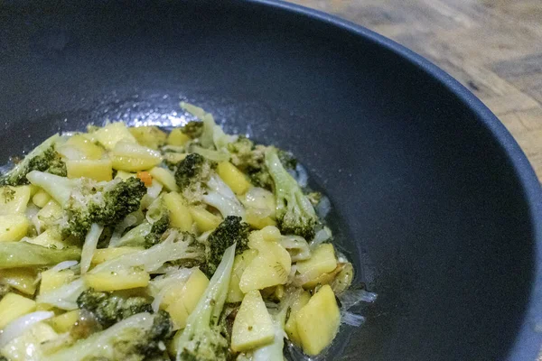 花椰菜炒菜 一张舒适的图片 是一个花椰菜炒菜 晚上在厨房里煮土豆 选定重点 — 图库照片