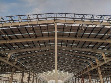 Çelik çatı inşaatı, yapı çeliği konsepti. Çelik çerçeve yapısı, çelik metal yapıdan alt manzara depo inşaatı. Modern hangar veya fabrika inşaatı çerçevesi.