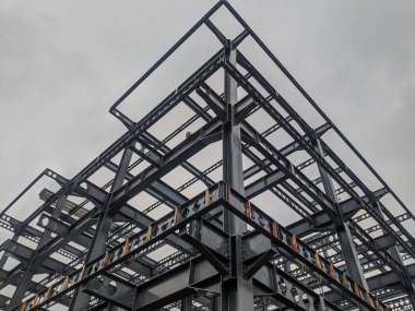 Çelik çerçeve yapısı, çelik çerçeve atölyesi mavi gökyüzüne karşı yapım aşamasında, çelik tesisat inşaatında siyah çelik çelik, yeni fabrika inşaatında çelik çatı kirişleri kurulumu,