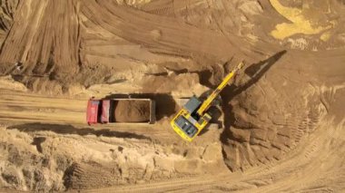 İnşaat alanında kamyonla çalışan kazıcı kum toplama işgücü.