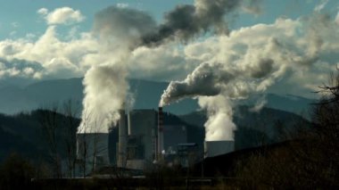 Hava kirliliği üreten endüstriyel bitki gücü karbon monoksit atığı fabrika tüpleri baca bacaları bulutlar üzerinde büyük siyah duman duman