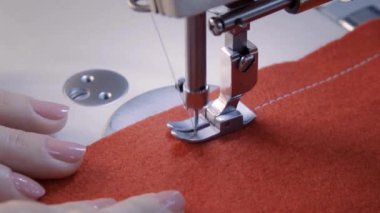 Evinde antika dikiş makinesi kullanan bir kadın koronavirüs salgını sırasında dikiş makinesinde çalışıyor apdemik maske takıyor.