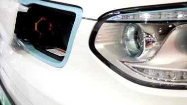 Bir arabayı şarj istasyonunda şarj etmek. Modern şarj aleti elektrikli bir arabaya takılı. Yenilikçi elektrikli hibrit araba şarj ediliyor