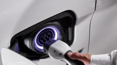 Elektrikli çevre aracı şarj oluyor. Şarj istasyonunda elektrikli araba şarj eden adama yaklaşın. Yeni yeşil enerji kavramı.