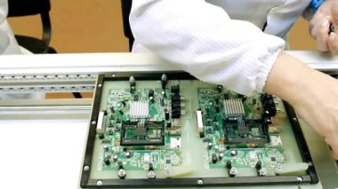 Mühendis, bilgisayar sistemi üzerine modern bir bilim laboratuvarında çalışıyor. Elektronik fabrika işçisi ana kartı ve kodlamayı test ediyor..