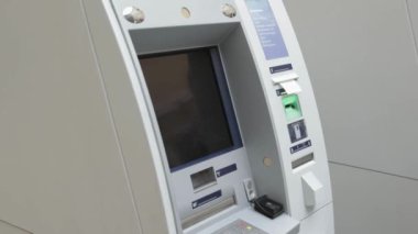 Bankamatik kasasına para çeken bir kredi kartı yerleştirirken yakın plan görüntüsü.
