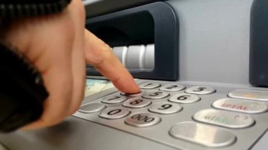 ATM adam eli pin numarasını girerken kapatıyor. Düğmelere basmak, pin anahtarı bankasına girmek.