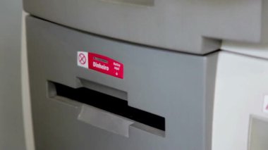 ATM çalışanı, bankadan para çekerken otomatik servis konsepti finansmanı kullanıyor.