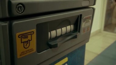 Bankamatik otomatik veznedar kredi kartı ekstrelerinden nakit para çekiyor.