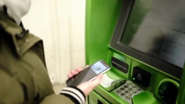 İnsan elleri ATM 'de işlem yapar, bankanın içinde kredi kartı olan para makinesini alır.