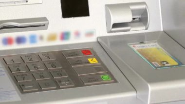 ATM adam eli pin numarasını girerken kapatıyor. Düğmelere basmak, pin anahtarı bankasına girmek.