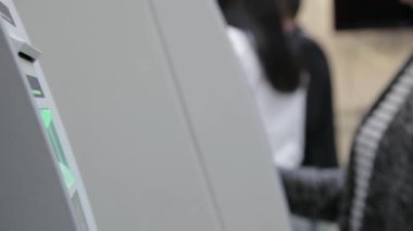Bankamatik kasasına para çeken bir kredi kartı yerleştirirken yakın plan görüntüsü.