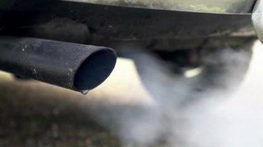 Bir arabanın kapanışı egzoz borusu kirliliği ekoloji arka planında egzoz dumanı