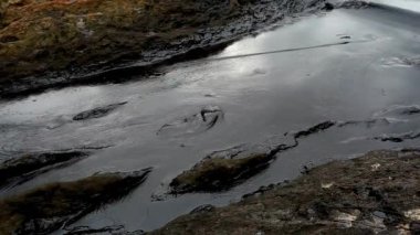 Deniz kıyısındaki petrol kirliliği yakın plan çekimleri mürekkep deseni kirli boya siyaha