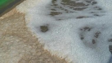 Kanaldan tortu havuzlarına akan lağım artıklarıyla birlikte kahverengi kum çamurlu su. geri dönüşüm