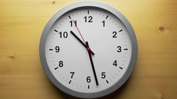 時間と分の手が時計回りに動くのを示す壁の時計の矢印を閉じる — ストック動画