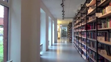 Halk kütüphanesinde kitaplık içinde raflar içinde birçok kitap ve araştırma bilimsel eğitim modern