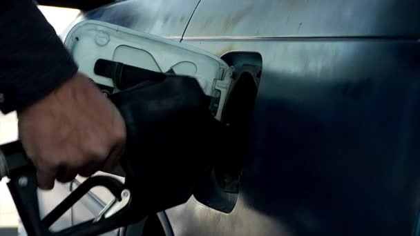 ガソリンスタンドで車を満たすために燃料ポンプを使う男 — ストック動画