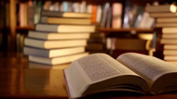 Buch Der Bibliothek Mit Geöffnetem Lehrbuch Und Verschwommenem Bücherregal Hintergrund — Stockvideo