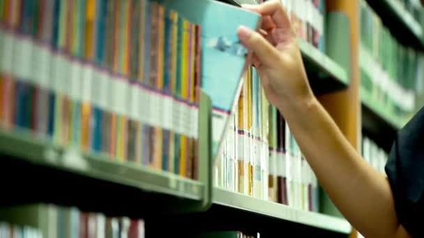 在一个大型的现代大学图书馆书店里 女性正在接触各种书架上的书籍 — 图库视频影像