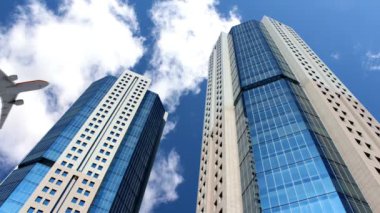 Modern ticaret bürosunun ve uçak binalarının düşük açılı görüntüsü Mavi aynalı gökdelen şirketinin gökyüzünü inşa ediyor.