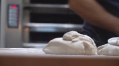 Şefin yakın plan resimleri fırıncı ekmek hamuru hazırlıyor hamur yoğurma tahtadan yapılmış pizzayı hazırlayın