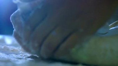 Şef ahşap masada hamur unu yoğuruyor hobi çekiminin keyfini çıkarıyor. 4K çekim.