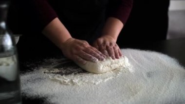 Profesyonel şef. Erkek aşçının elleri hamur unu yoğuruyor. Mutfakta çalışıyor.